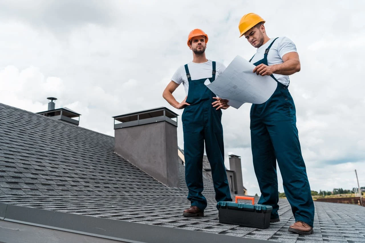 men reading plans on a roof